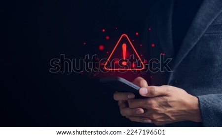 Businessman or User holding smartphone with triangle caution warning sign red for notification error and maintenance concept. warning sign exclamation,
