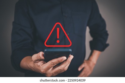 Businessman or User, programmer, developer using smart phone with triangle caution warning sign for notification error and maintenance warning and safety concept. - Shutterstock ID 2250924039