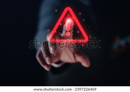 Businessman uses laptop computer with warning triangle sign or exclamation mark for error notification and technology maintenance concept.
