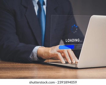 Businessman uses a laptop for loading and processing data on a virtual screen while sitting at the table. Software progress loading bar. Data management system. Document management system