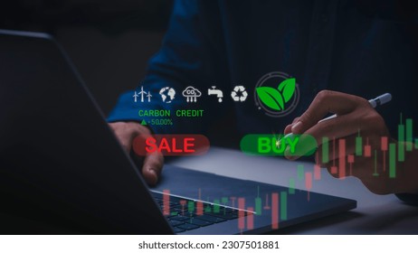 Businessman uses technology to exchange carbon credits on virtual screen with net zero emissions, clean technology, renewable energy. - Shutterstock ID 2307501881