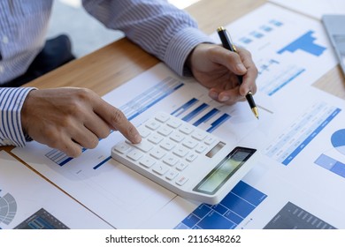 Businessman Using A Calculator To Calculate Numbers On A Company's Financial Documents, He Is Analyzing Historical Financial Data To Plan How To Grow The Company. Financial Concept.