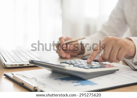 Businessman using a calculator to calculate the numbers