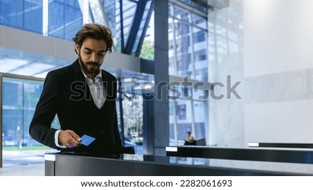 Businessman using card to open automatic gate machine in office building. Male using smart card to open automatic gate machine in office building. Working routine concept.