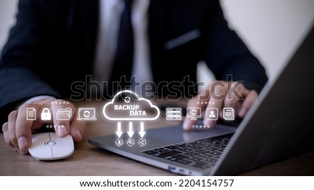 Businessman using a computer to backup storage data Internet technology concept for backup online documentation database and digital file storage system or software,file access, doc sharing.