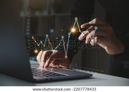 Businessman using computer with graph growth analysis on virtual screen, Growing revenue and Financial business investment concept.