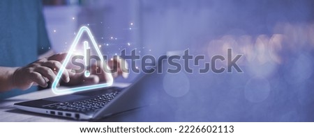 Businessman using computer laptop with triangle caution warning sing for notification error and maintenance concept.	