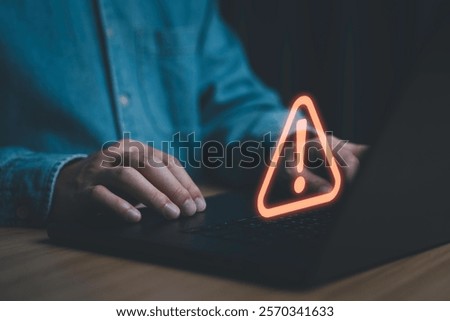 Businessman using computer laptop with triangle caution warning sign for notification error and maintenance concept.