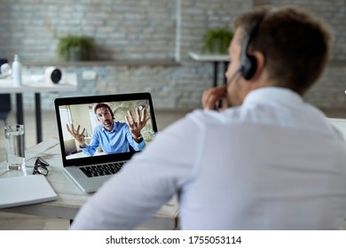 Businessman using computer while having video call and talking to his colleague from the office.  - Shutterstock ID 1755053114
