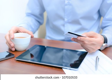 Businessman using a credit card and digital tablet for buying on-line. - Powered by Shutterstock