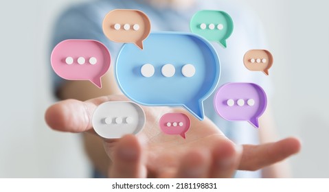 Businessman using digital colorful speech bubbles talk icons. Minimal conversation or social media messages floating over user hand. 3D rendering
