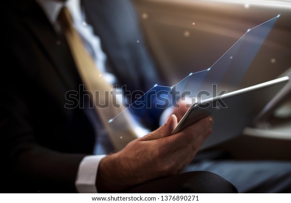 Businessman using a\
digital tablet in a\
car