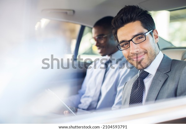 Businessman using\
digital tablet in car back\
seat