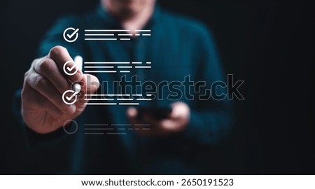 Businessman using electronic pend tick correct tick sign mark to checklist for quality assurance and certification concept.