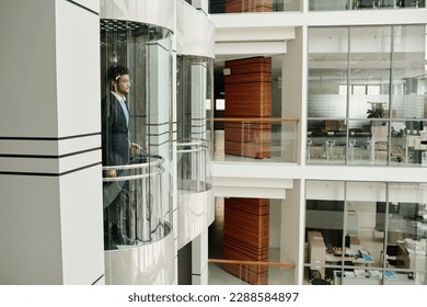 Businessman using elevator in office centre