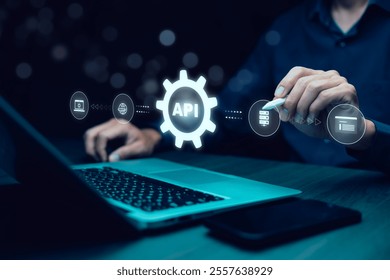 Hombre de negocios que utiliza el ordenador portátil con el icono de la API en una pantalla virtual en el fondo del dispositivo de la tecnología de Internet, interfaz de programación de la aplicación de la API conecta los servicios en la comunicación de datos de Internet.