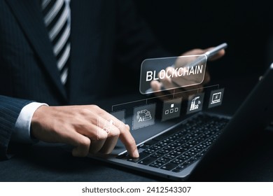 Businessman using laptop with blockchain icon in hand for blockchain industry 4.0 technology on virtual screen. Blockchain industrial strategy concept.