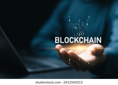 Businessman using laptop with blockchain icon in hand for blockchain industry 4.0 technology on virtual screen. Blockchain industrial strategy concept.