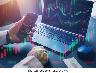 Businessman using  laptop computer and phone  with financial graphs and statistics on monitor. Technical price candlestick chart graph and indicator stock online trading. Forex investment business.  - Shutterstock ID 1823040740