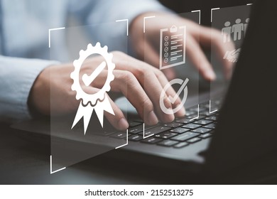 Businessman using laptop computer with quality assurance and document icon for ISO or International Standard Organisation which related quality control and continuous improvement concept.