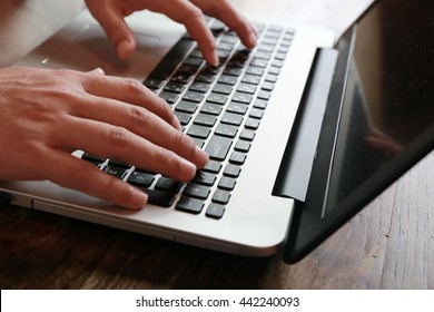 Businessman using laptop computer,Hands multitasking man working connecting internet,  finger typing on keyboard laptop computer sitting at wooden table.Success life