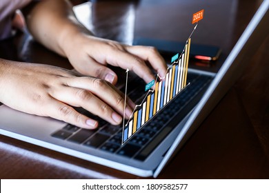 Businessman using a laptop with data analytics and statistics information business technology on table top.