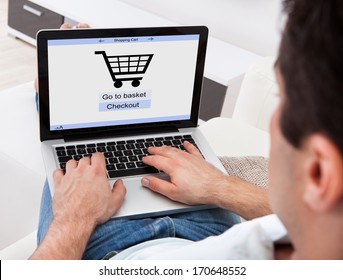 Businessman Using Laptop With Online Shopping Application On A Screen