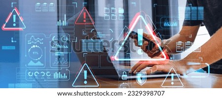 Businessman using laptop and phone in hands. Attention warning alert sign hologram and business infographics with digital chart. Concept of system error, malware and emergency