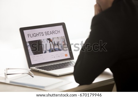 Businessman using laptop for searching cheap low cost business flight, choosing airfare deal, comparing trip prices, booking airplane ticket online on web service, focus on screen, close up back view 