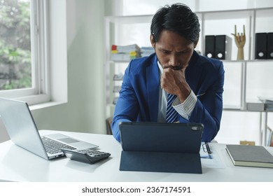 Businessman using laptop and tablet Data graph document to analyze stock data Financial investment to check company profits startup business idea - Shutterstock ID 2367174591