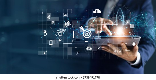 Businessman using laptop and touching a transparent rocket is launching and flying out, Business start up, Icon marketing on modern virtual interface.