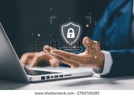 Businessman using laptop with virtual security shield and password protection interface, representing cybersecurity, data privacy, secure login and online protection technology.