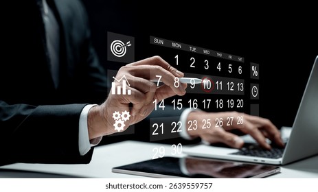 Businessman using a laptop while marking the date on a virtual calendar on a tablet screen. Technology innovation on a virtual screen. Concept of schedule or time management