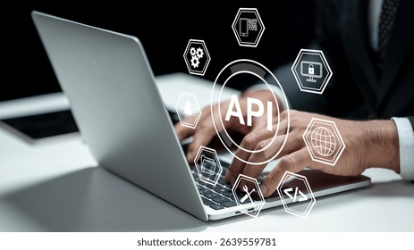 Businessman using a laptop while showing an icon of API. Tablet on the table. Technology innovation on a virtual screen. Concept of Application Programming Interface
