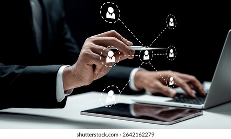 Businessman using a laptop while touching the connected people icon on the tablet screen. Technology innovation on a virtual screen. Concept of public relations