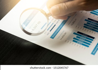 Businessman using magnifier glass  for financial data analysis and find the best company from stock market. Value investor concept.