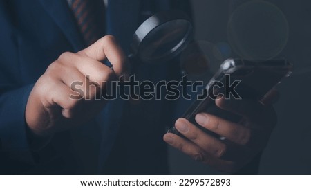 Businessman using magnifying glass and mobile smartphone searching data. Information in the internet world search technology Search Engine Optimization(SEO).