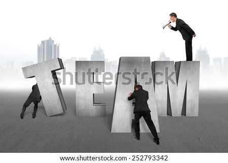 Businessman using megaphone commanding employees to move TEAM 3D concrete word together with cityscape