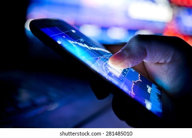 A businessman using a mobile device to check stocks and market data.