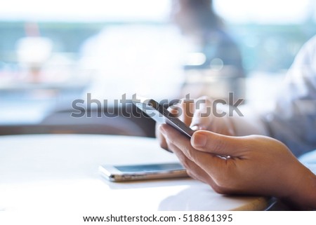 Businessman using mobile payments in office background