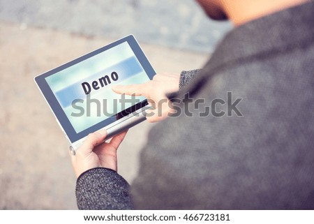 Businessman using modern digital tablet and pressing on Demo button. Toned photo.