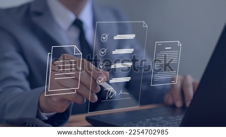 Businessman using pen to sign electronic documents with virtual screen on laptop computer on table Electronic signature concept. Technology