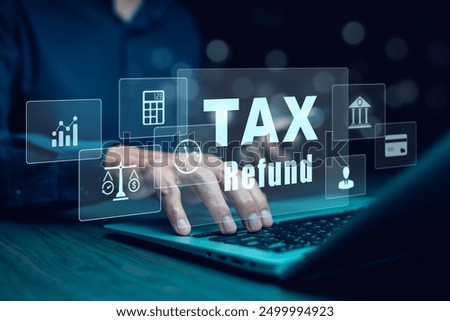 Businessman using a pen to write a notebook with TAX REFUND and refund tax of duty taxation business, graphs and chart being demonstrated on the screen media,  tablet pc and selecting tax refund.