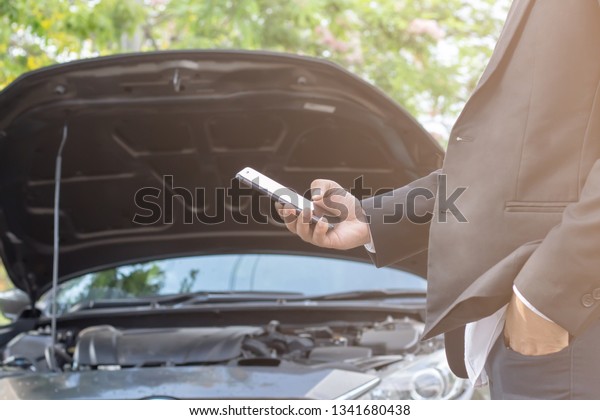businessman is using the phone in\
asking for help when his car is broken,Motorist Broken Down On\
Country Road Phoning For Help ,Broken car\
Concept