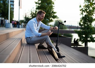Businessman using the phone while sitting on the stairs. Happy man using the phone	