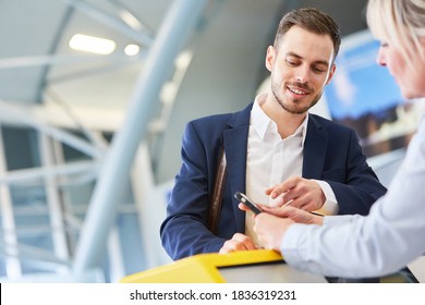 Businessman Using Smartphone At Check In Or Baggage Drop Off Counter In Airport