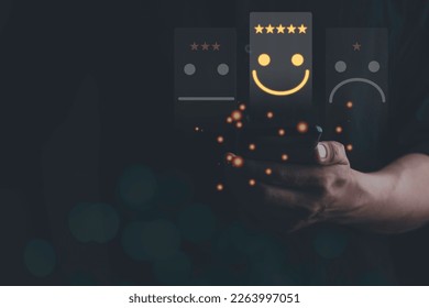 Businessman using smartphone for choose smiley face icon for client evaluation and customer satisfaction after use product and service concept. Customer service and satisfaction concept. Copy Space. - Shutterstock ID 2263997051