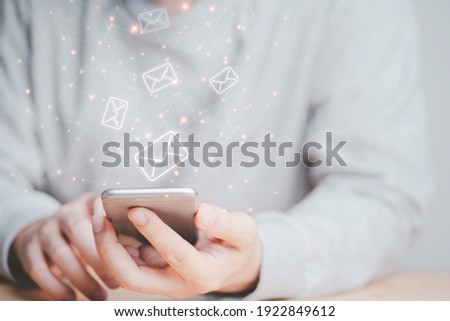 Businessman using smartphone with e-mail icon , technology concept.