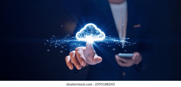 Businessman using smartphone and interacting with glowing digital cloud network, representing cloud computing and data connectivity on dark background.