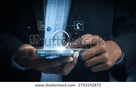 Businessman using smartphone interface to control automated business processes with icons representing technology